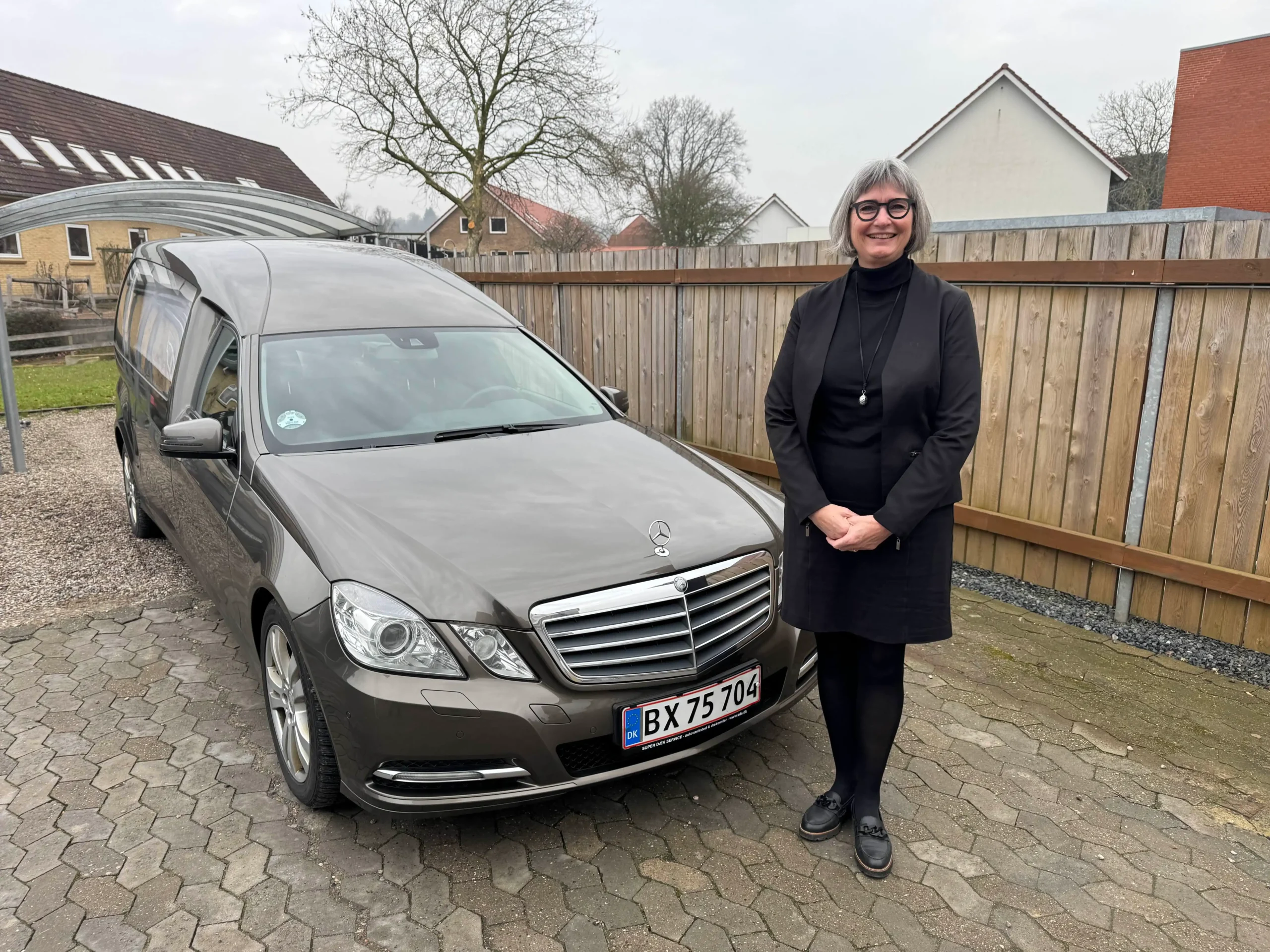 bedemand inga jørgensen står foran rustvogn 